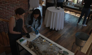 Woman shucking oysters; Photo Credit: Digital Edge