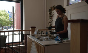 Woman shucking oysters; Photo Credit: Digital Edge
