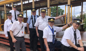 Group of conductors standing next to train; Photo Credit: Seashore Trolley Museum Collection