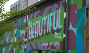 Green and purple mural on building; Photo Credit: Digital Edge