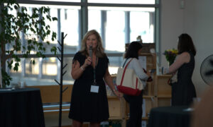 Woman speaking into microphone; Photo Credit: Digital Edge