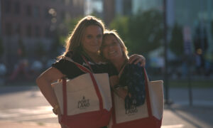 Two women smiling with Visit Portland bags; Photo Credit: Digital Edge