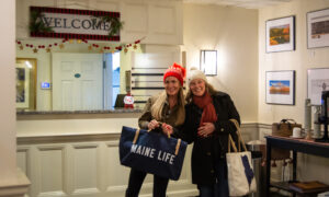 Women smiling holding bags in hotel lobby; Photo Credit: Lauren Witt at Visit Portland
