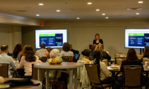 Speaker giving presentation to a room of people; Photo Credit: Lauren Witt at Visit Portland