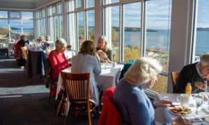 People enjoying McKernan Inn sun room with a view; Photo Credit: Lauren Witt at Visit Portland