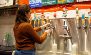 Pouring beer from Rising Tide taps; Photo Credit: Lauren Witt at Visit Portland