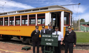 Conductors standing in front of yellow train; Photo Credit: Seashore Trolley Museum Collection