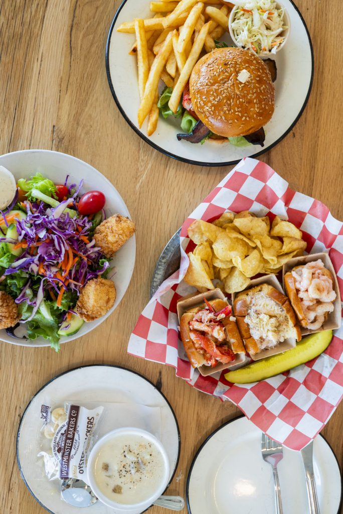 A top-down view of a table spread with various seafood dishes and sides in Portland Maine.
