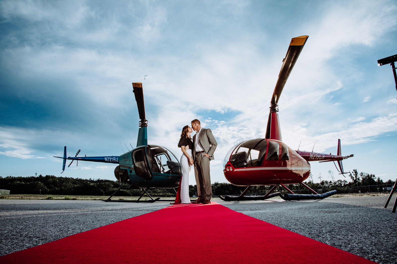 Couple in front of Helicopters. Photo Credit: Pine Tree Helicopters