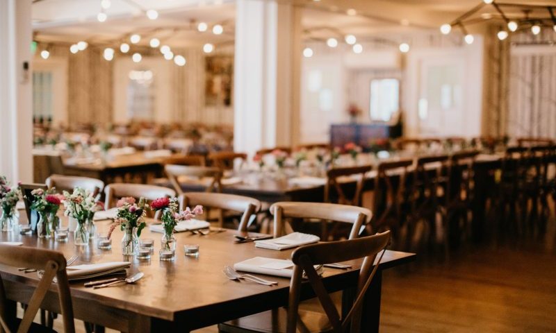 A banquet hall with long wooden tables set for a formal event in Portland Maine.
