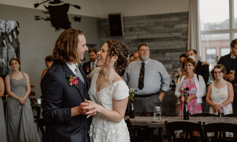 A bride and groom laughing while dancing at their wedding reception in Portland Maine.