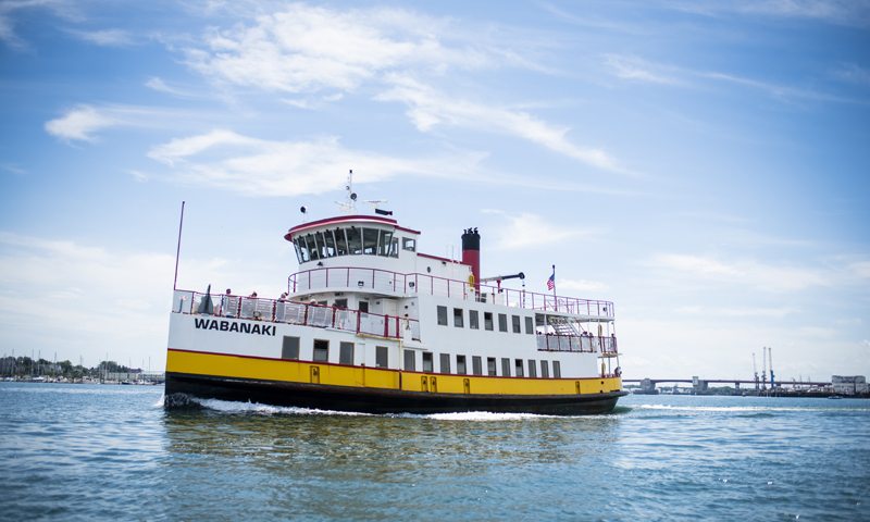 The Wabanaki ferry boat traveling across the water under a blue sky in Portland Maine.