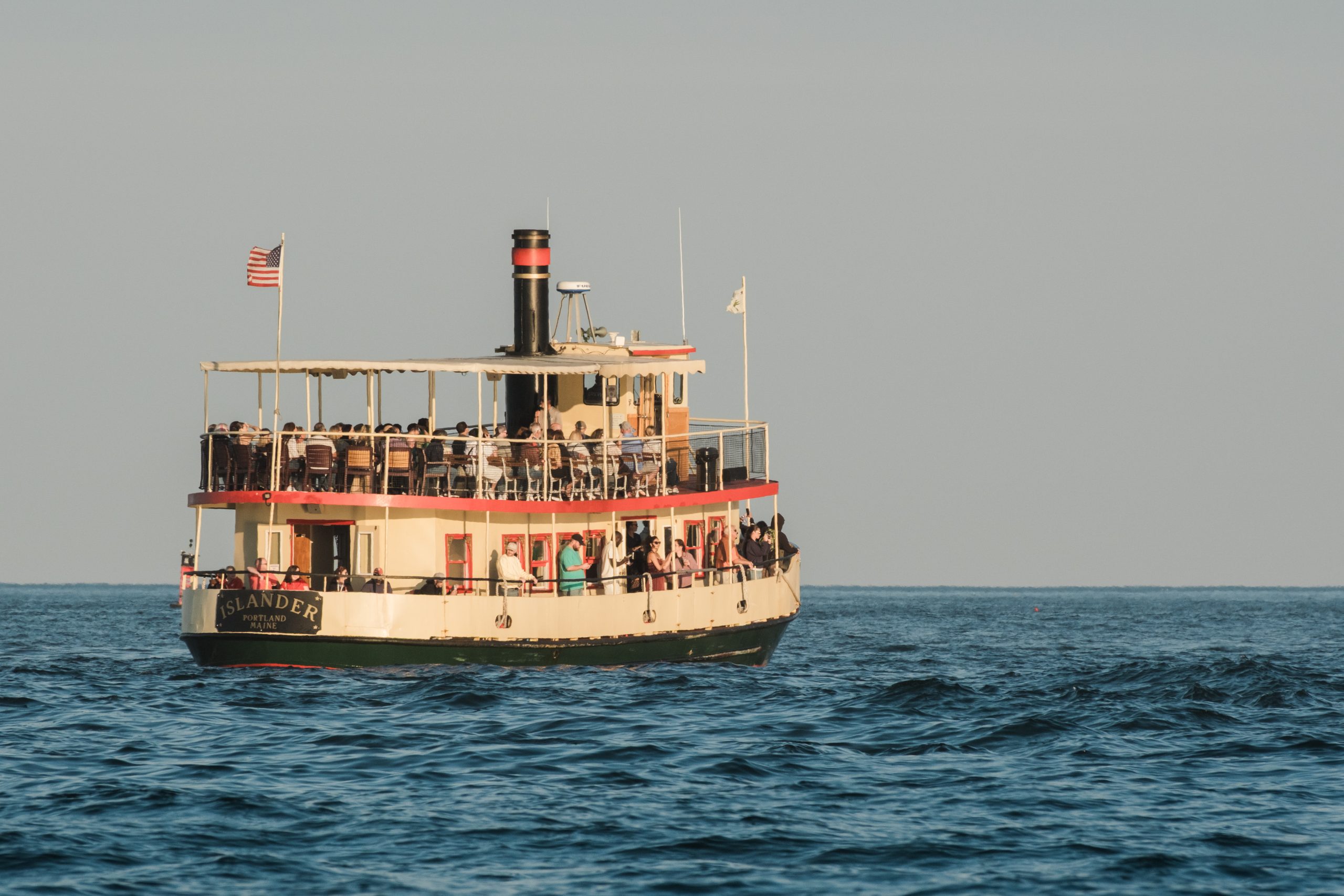 A passenger ferry named Islander cruising on calm ocean waters in Portland Maine.