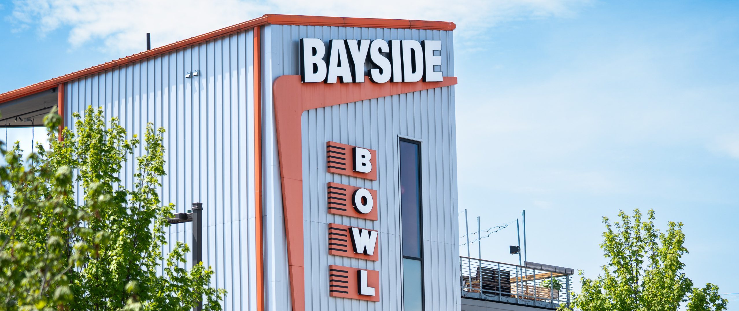 The exterior of a Bayside Bowl building with a rooftop bar sign in Portland Maine.