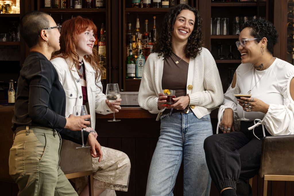 Women Laughing with Drinks at Portland Harbor Hotel. Photo credit: Nicole Wolf
