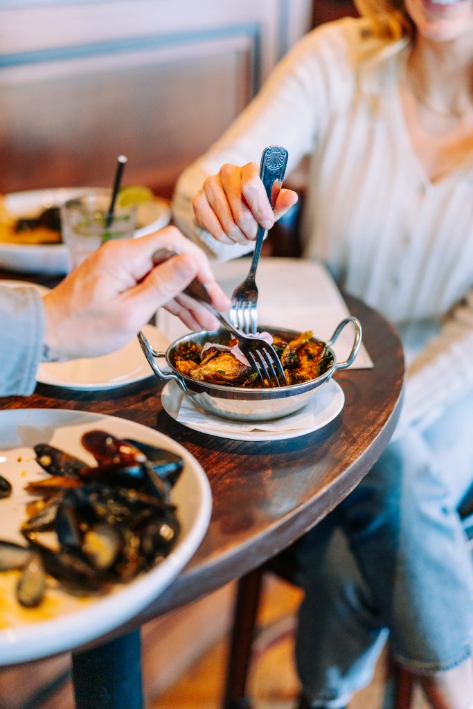 Couple Sharing Appetizer at Boone's Fish House and Oyster Room. Photo credit: Mat Trogner