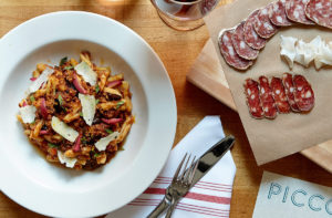 Plated pasta meal next to charcutterie board - Photo Courtesy of: Wine Wise Events